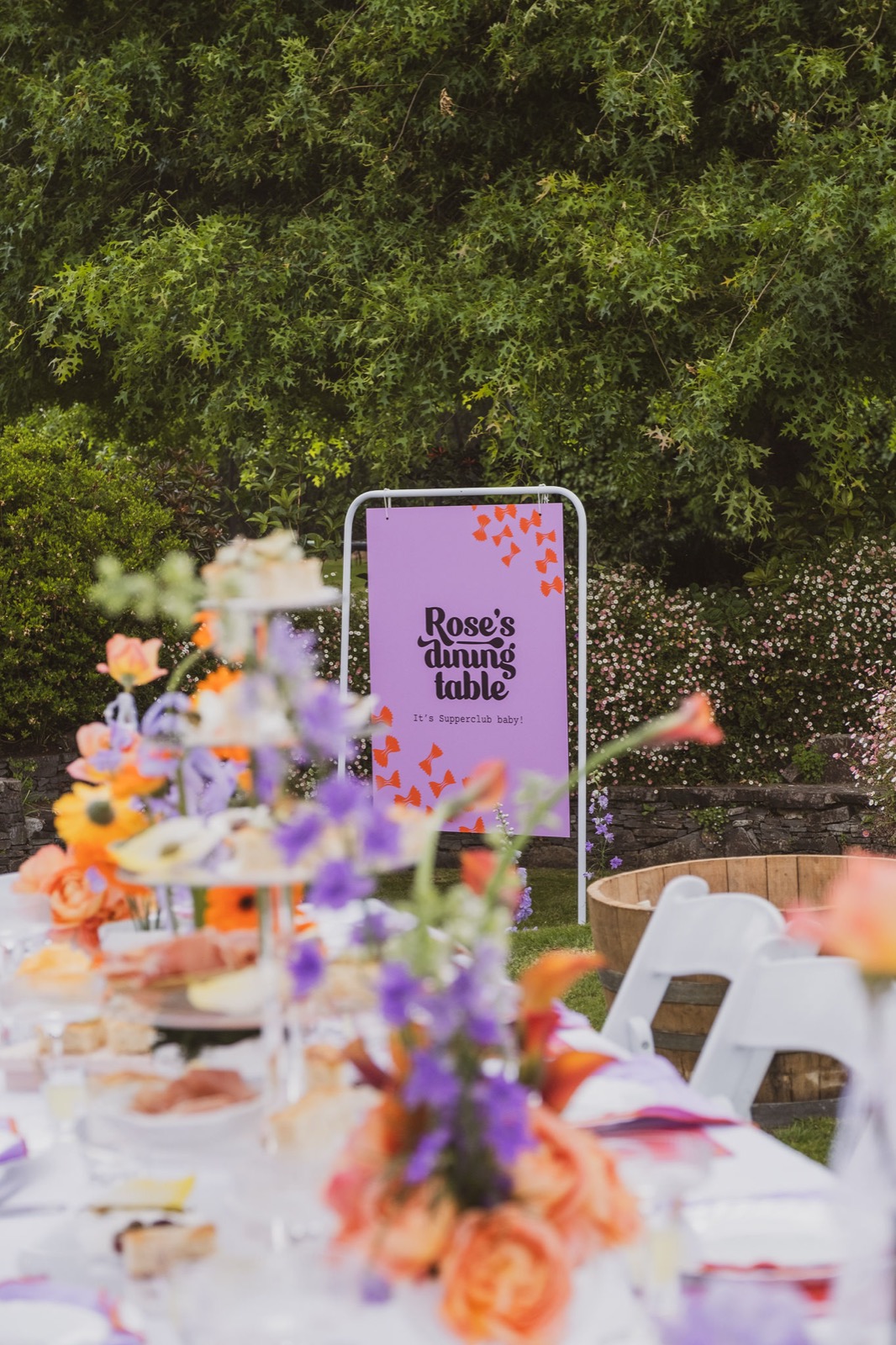 A Rose's Dining Table event table set with flowers and the Rose's Dining Table sign